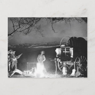 Cowboys leker och sjunger runt en campfire vykort