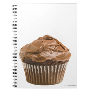 Cupkaka med chokladicering, studio shot anteckningsbok med spiral