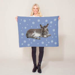 Cute baby donkey med snöflingor på blå fleecefilt