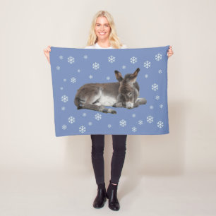 Cute baby donkey med snöflingor på blå fleecefilt