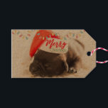 Cute Puppy-Hund i en Red Santa Hat-jul Presentetikett<br><div class="desc">Ge märkre med ett vackert foto av en pug marionett som sover medan han bar en röd tomhatt. God jul är skrivet på hattens band, i ett handskrivet trendig, på den festliga färg röda och grönten. Jul ljus som har stigit upp och ner skapar ytterligare säsong helgdag. På baksidan står...</div>