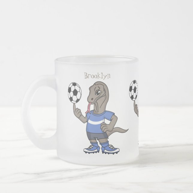 Cute roligt Komodo draon spelar fotboll tecknad Frostad Glasmugg (Vänster)