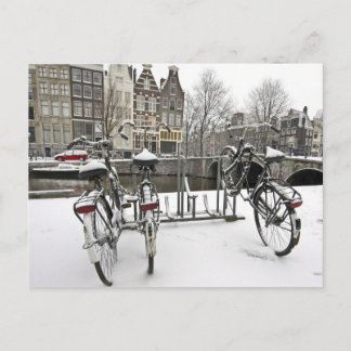 Cyklar i snöig Amsterdam i Nederländerna Vykort