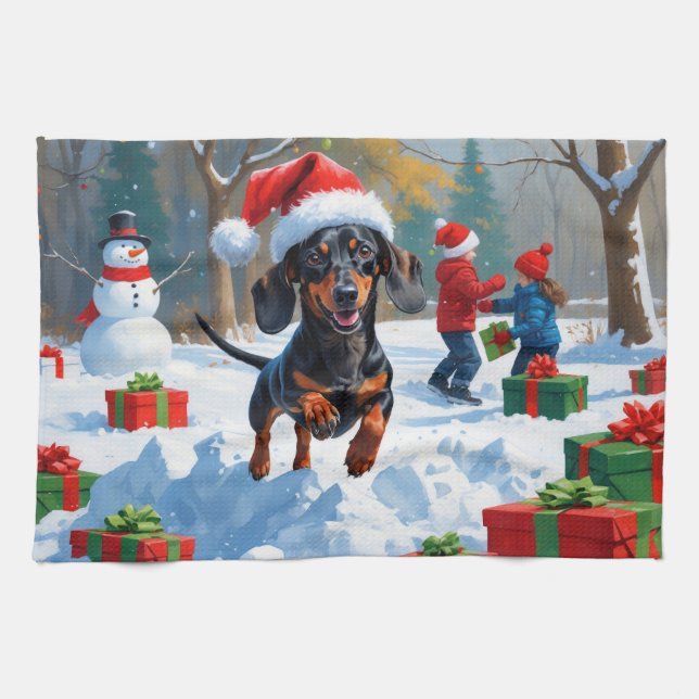 Dachshund springer i snö med julhatt kökshandduk (Horisontell)