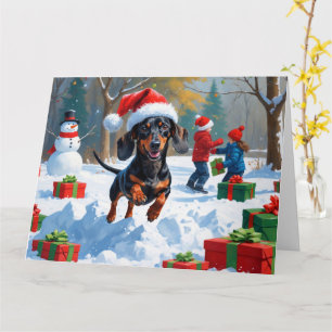 Dachshund springer i snö med julhatt kort
