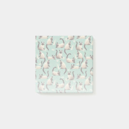 Dåliga siamesiska katter som knackar Saker över Post-it Block