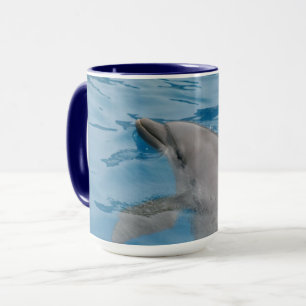 Delfin glider genom klart blått vatten mugg