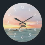 Delfiner Beach Sunset Ocean Sjölandskap Vattenfärg Stor Klocka<br><div class="desc">Beach Tema klocka är en sjölandskap med vattenfärg som målar upp en lekfull pod av delfiner och simmar in i havets solnedgång. Perfekt för strandhus, nautiska, kustnära och tropiska dekorationsteman. Bild av KL Lagrar.</div>