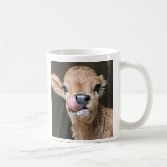 Den mycket små förtjusande kalven grejar lite på kaffemugg (Höger)