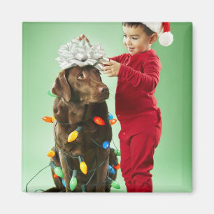 Den unga pojken som slår in jul, tänder runt om magnet