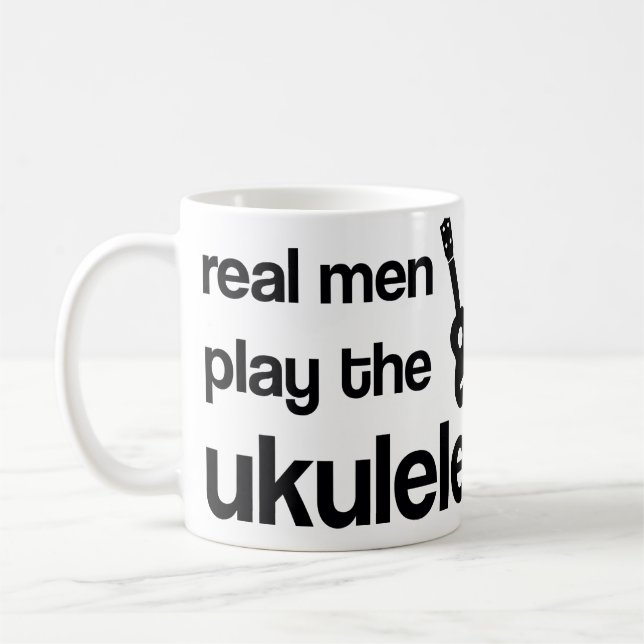 DEN VERKLIGA MANAR LEKER UKULELEN KAFFEMUGG (Vänster)