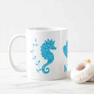 Det blåttseahorsen och snäckskal tillfogar den kaffemugg