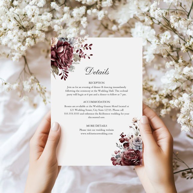 Detaljkort för Sage Grönt & Burgundy Blommigt Bröl Inbjudningar (Sage Green & Burgundy Floral Wedding Details Card in hands next to tiny white flowers)
