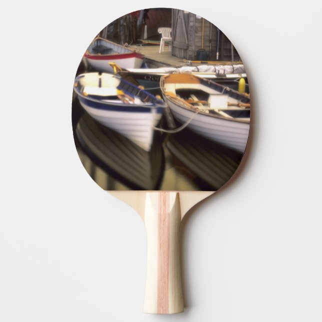 Dimmar omger fyra båtar vid kajen. pingisracket (Framsidan)