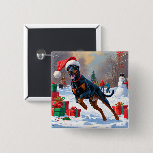 Dobermann springer i snö med julhatt knapp