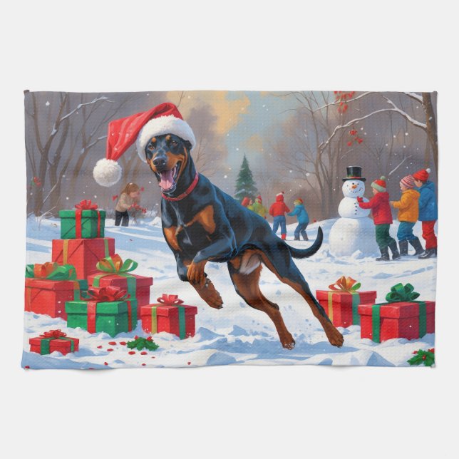 Dobermann springer i snö med julhatt kökshandduk (Horisontell)