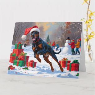 Dobermann springer i snö med julhatt kort