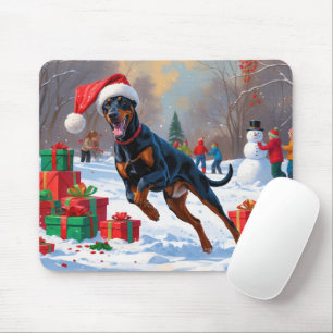 Dobermann springer i snö med julhatt musmatta