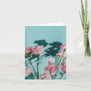 Drömska rosa nejlikblommor på blå bakgrund kort