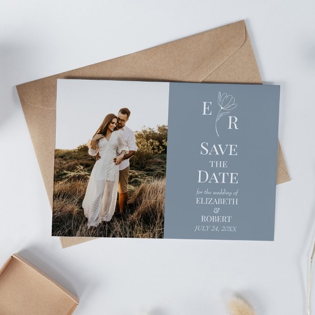 Dusty Blue Blommigt Monogram Photo Save Date Inbjudningar (Dusty Blue Floral Monogram Custom Photo Wedding Invitation on white table with neutral decoration.)