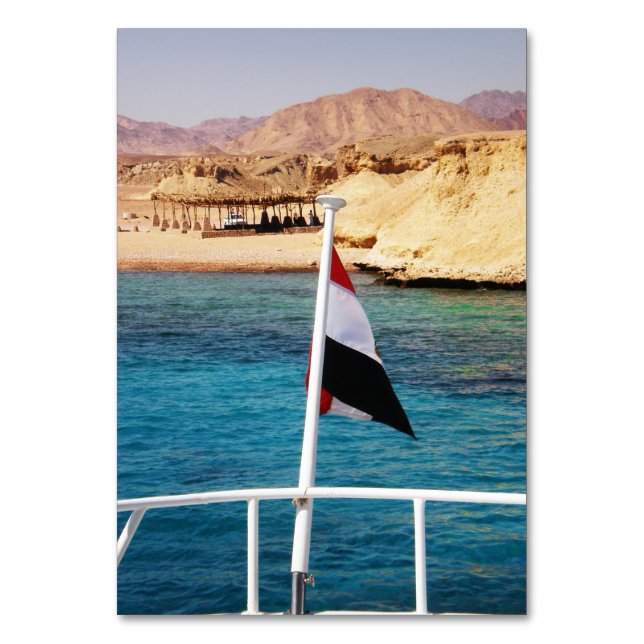 Egyptisk flagga mot bakgrund av azure vatten bordsnummer (Framsidan)