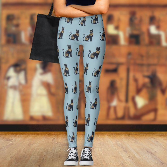 Egyptisk svart kattmönstrad dammig blå leggings (A pair of light blue leggings with a pattern of Egyptian-style black and faux gold cats)