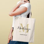 Elegant Guld Black Personligt bröllp Bridesmaid Na Tygkasse<br><div class="desc">Elegant personligt bröllp tote-väskan har en personlig monogramtypografi med det moderna kalligrafiskriptet namn och serif monogram initialt i rik guld och svart färg. Innehåller anpassningsbar för en brudens sida-rubrik som "BRIDESMAID" eller annan föredragen ordalydelse.</div>