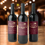 Elegant Script Burgundy Red Guld Studenten Vinflaska Etikett<br><div class="desc">Elegant-burgundröd studentfest-vin-etiketter med "klass av" i en lätt guld illustration av lagerkrans med gradersockel och diplom,  student namn i ett skript av snyggt guld och "Grattisar" och deras skolnamn i modern guld typografi.</div>