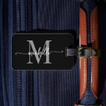 Elegant Stilfull Svart Grå Monogram Initial Skrift Bagagebricka<br><div class="desc">Tjejaktig Stilren Modern Elegant Svart och Grå Monogram Initial Namnskrift Anpassad Personlig Resväskemärke. Denna design har ett förnamn i en vacker handskriven svansfont kalligrafi (eller typografi) med monograminitial, adressinformation i grått och vitt på svart. Dessa är lätta att anpassa. Stilrent feminint present för bröllop, bröllopsshow, 16-årsdag, examen och för alla...</div>