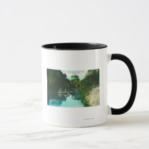 En bäckplats med familjen i en kanot mugg