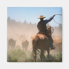 En cowboy som arbetar med hjorden på en boskap magnet