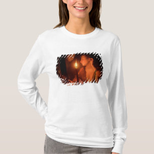 En dam som beundrar ett örhänge vid Candlelight T-shirt
