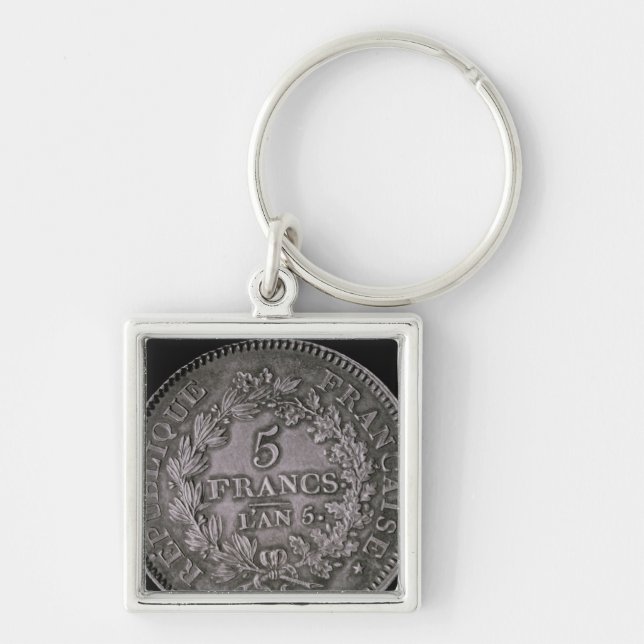 En dunka av tjugo sols fyrkantig silverfärgad nyckelring (Framsidan)