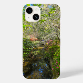 en flod i trädgården omgiven av blommor