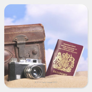 En gammal läderväska, retrokamera och fyrkantigt klistermärke