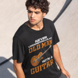 En gammal man med en gitarsvart t shirt<br><div class="desc">En gammal man med en guitar svart T-skirt</div>
