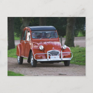 En gammal röd Citroen 2CV bil med en leende kvinna Vykort