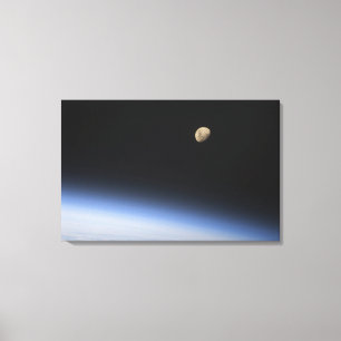 En gibbous måne som är synlig ovanför jord canvastryck