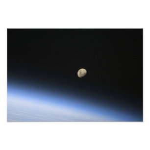 En gibbous måne som är synlig ovanför jord fototryck