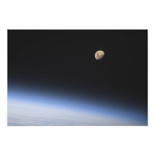 En gibbous måne som är synlig ovanför jord fototryck