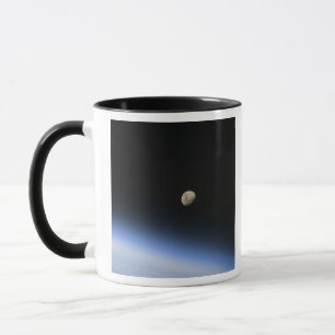 En gibbous måne som är synlig ovanför jord mugg