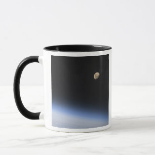 En gibbous måne som är synlig ovanför jord mugg