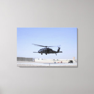 En HH-60G stenlägger höken som tar av från läg Canvastryck