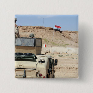 En instruktör vakar som militär från Iraks armé Knapp