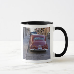 En klassisk gammal röd Peugeotbil parkerad på en g Mugg