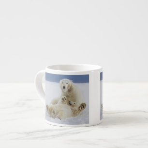 En kvinnlig isbjörn och hennes unge leker i snön espressomugg