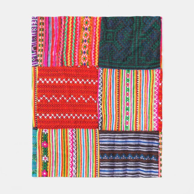 en lapptäcke i multifärgad som ligger vid stil fleecefilt (Framsidan)