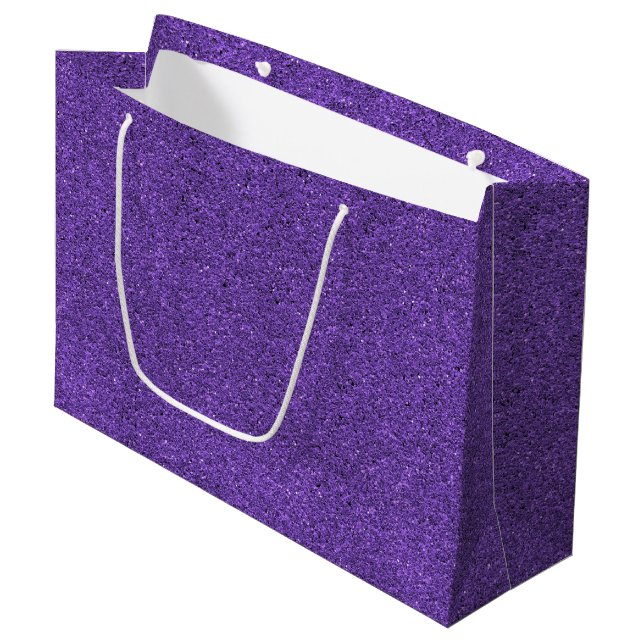 En lila glitterpresentbag med ett vitt handtag (Framsidan Vinklad)