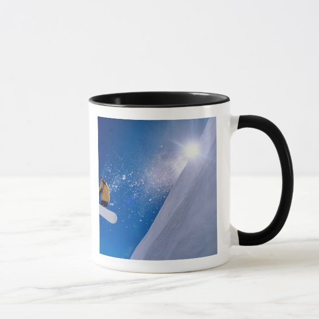 En man som flyger genom luft på en snowboard med mugg (Höger)