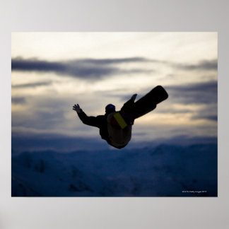 En manlig snowboarder gör en backspegel medan han poster
